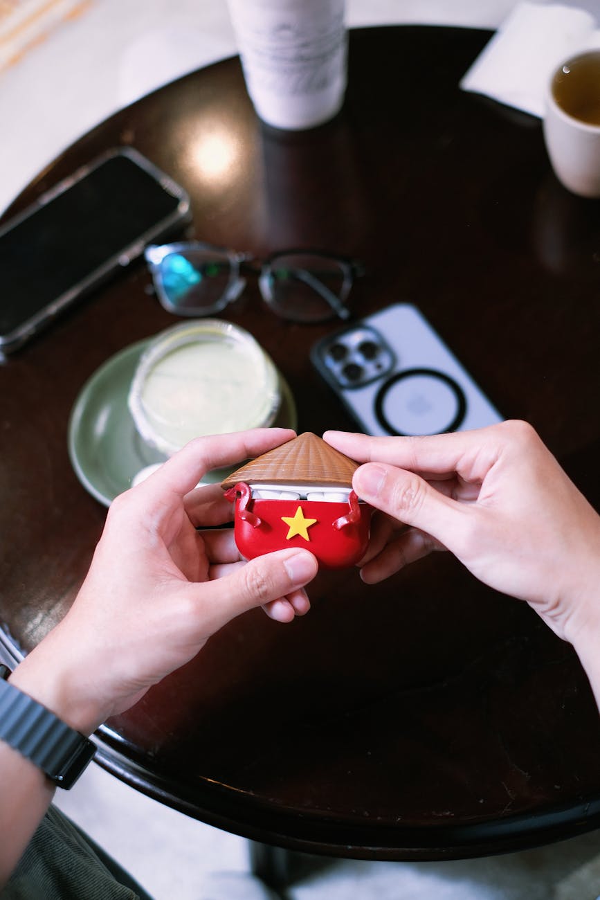 Colorful Vietnamese hat-style Airpod case on cafe table, Vietnam.