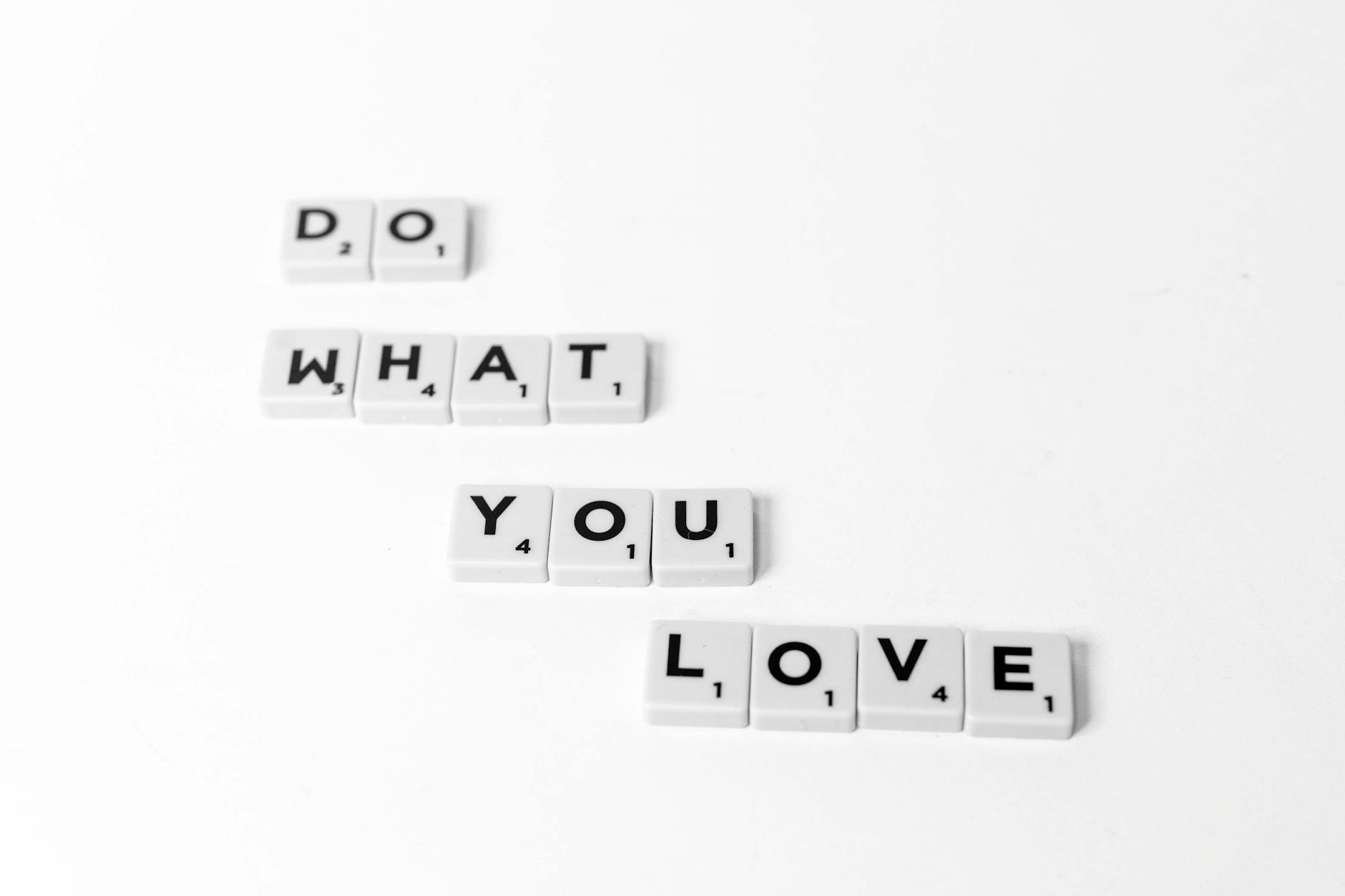 Scrabble tiles spelling 'Do What You Love' on a minimalist white background.