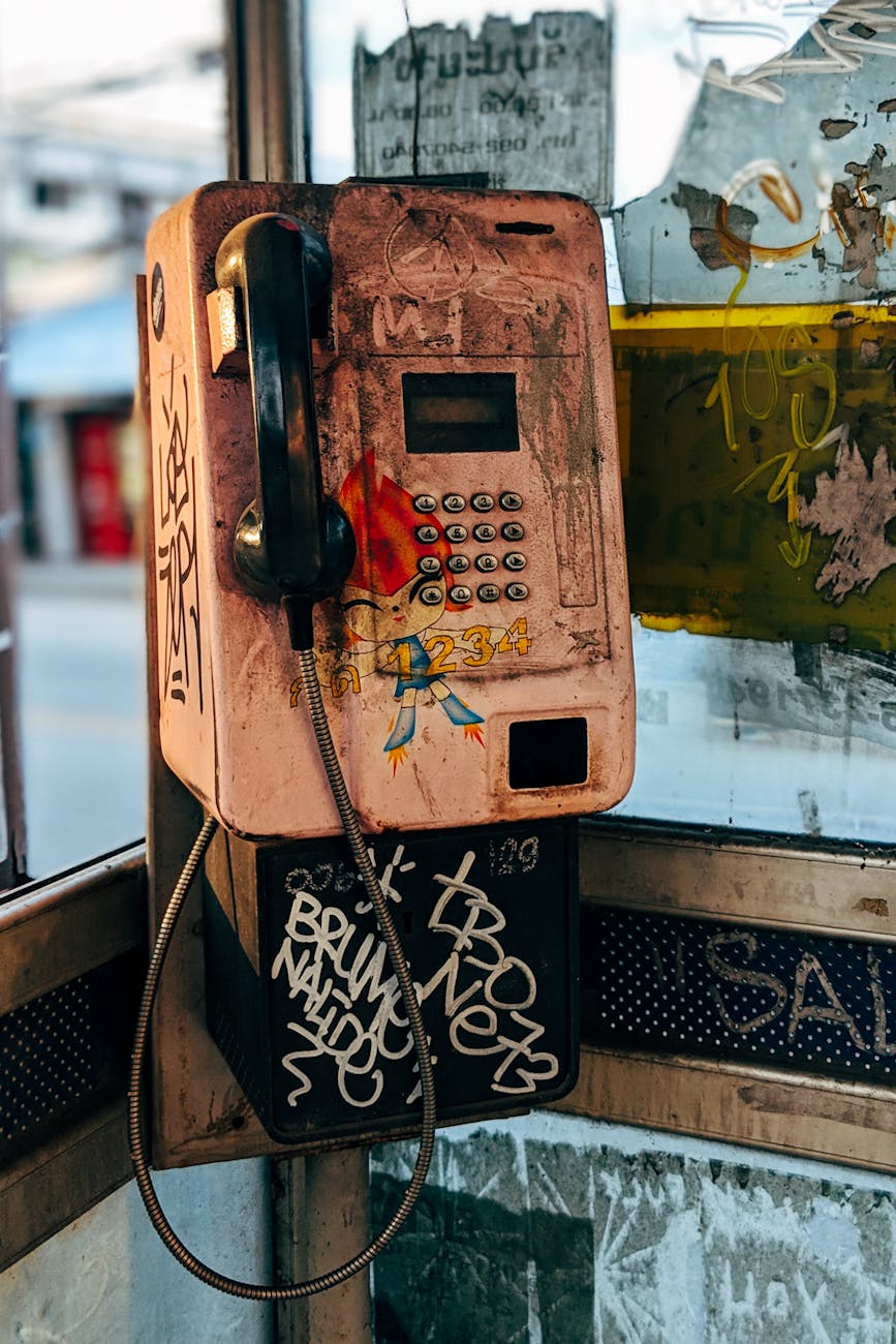 A retro phone booth with graffiti and urban decay creating a nostalgic vibe.