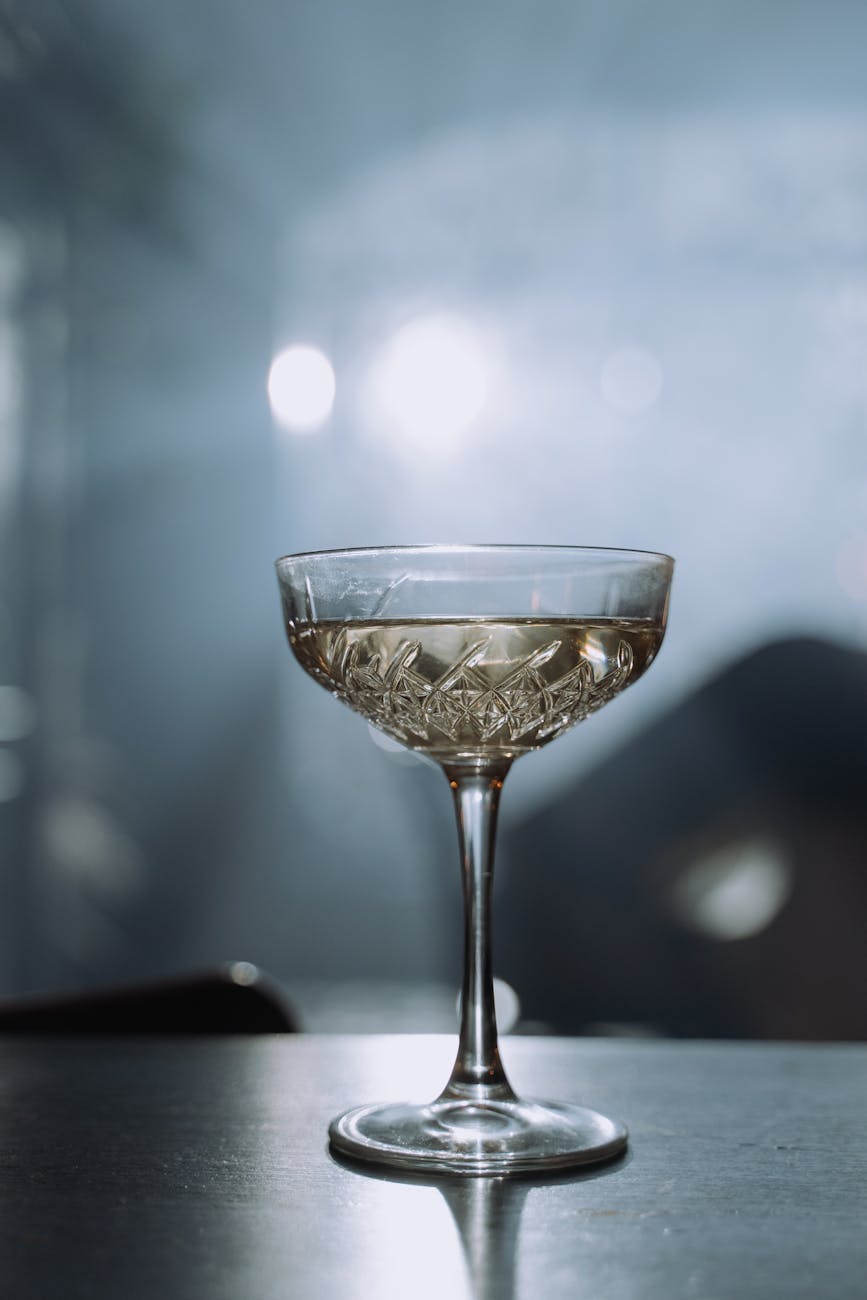 Crystal champagne glass with bubbles. Stylish and elegant drink setting in soft lighting.