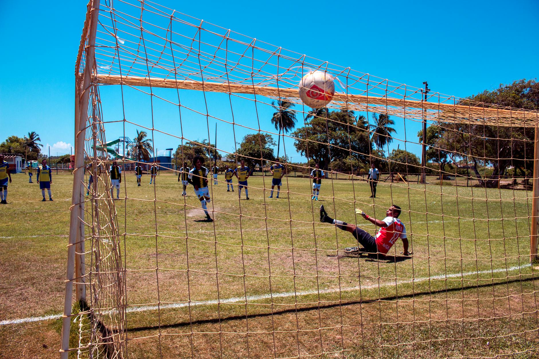 A thrilling moment during a soccer match in Aracaju, Brazil with a goalkeeper missing a challenging save.